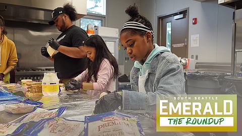 A young volunteer prepares turkey sandwiches to give away to families at Othello Village during the 2018 Turkey Bowl Week.