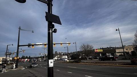 Black Flock Safety automated license plate reader camera mounted on a pole overlooking the intersection of Rainier Avenue South and SW Seventh Street in Renton, Washington.