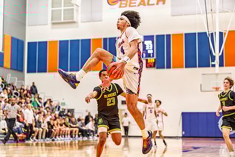 Basketball player Tyran Stokes passes a ball through his legs mid-air at Rainier Beach High School.