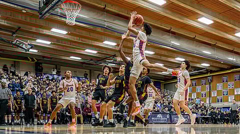 Rainier Beach basketball player Kam Babbs shoots a basket during a game against Bishop O'Dea. Teammates Tariq Shabazz and Achilles Reyna look on.