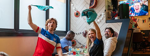 Austin Taylor and Morgan McCorkle celebrate at the Rough & Tumble Pub in Columbia City on June 25 after the U.S. scores against Turkey. Turkey won the match 3–2, but the U.S. had already secured a place in the round of 32.