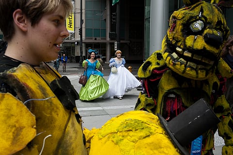 Sarah Kauppila of Enumclaw, dressed as Cinderella, and her mother, Luanne Kauppila, dressed as one of Cinderella's evil step-sisters Griselda, make their way into GeekGirlCon on Sunday, October 9, 2016 at the Washington State Convention Center in downtown Seattle. In the foreground, Kaitlynne Fowler, left, chats with her twin, Makenna Fowler. The pair are dressed as characters from the video game "Five Nights at Freddy's."