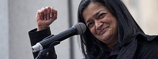 A close-up of Pramila Jayapal raising her fist.