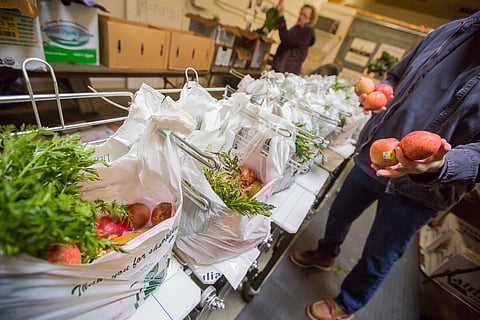 People pack food bags for the Good Food Bag program at the Tilth Alliance's headquarters in Seattle, Washington, on April 4, 2018. (Photo: Carolyn Bick)