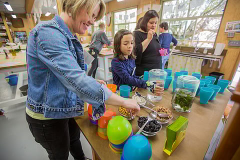 From left to right, Jennifer Alviar, Madeline Alviar, and Angie Escoto munch on snacks, before cooking class at Green Plate Special in Seattle, Washington, on May 1, 2018. (Photo: Carolyn Bick)