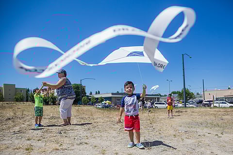Marcos San Martin, center, flies a kite, during the Othello-bration at Othello Square in Seattle, Washington, on June 16, 2018. (Photo: Carolyn Bick)