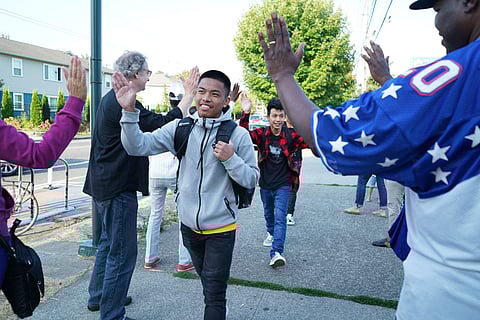 Members of the Rainier Beach community high fived students as they arrived for their first day of school at Rainier Beach High School in 2018. (Photo: Susan Fried)