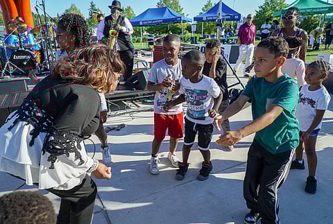 Josephine Howell dances with some children during the 46th ROOTS Family Picnic at Jimi Hendrix Park. (Photo: Susan Fried)