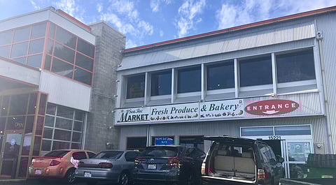 Cars parked outside SeaTac Market, which sells produce, dry goods, and furniture in West African styles.