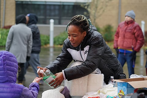 Keisha Kelly squirts hand sanitizer on a child's hand at the Feed The Beach event at the Rainier Beach Community Center. (Photo: Susan Fried)