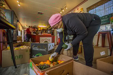 Ariel Bangs sorts through produce inside Cafe Red in Seattle, Washington, on April 6, 2020. (Photo: Carolyn Bick)