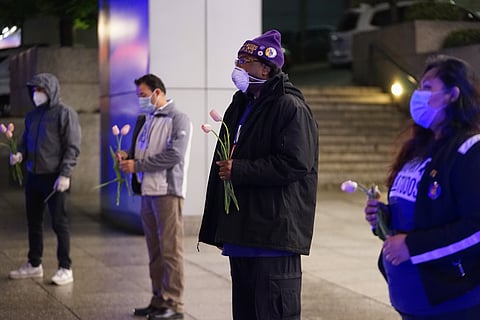 Mark Guthrie Sr. and other SEUI essential workers hold flowers during a moment of silence for workers effected by COVID-19.
