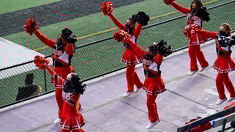 Cleveland High School cheerleaders cheer with facemasks at a high school football game. (Photo: Susan Fried)