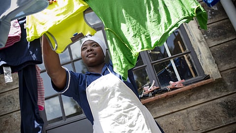 Lucy Nyangasi — 26 years old — goes about her daily household work in the house of the family she works for. Image is attributed to the Solidarity Center (under a Creative Commons, CC BY 2.0 license).