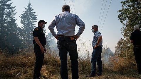 Washington Gov. Jay Inslee stands with firefighters as they survey the scene during the 2020 fire season. Image is attributed to the Flickr account of Gov. Jay and First Lady Trudi Inslee (under a Creative Commons, CC BY-ND 2.0 license).