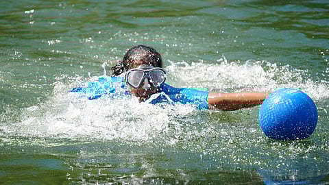 A boy swims to a ball in Lake Washington during a heat wave in 2021. (Photo: Susan Fried)