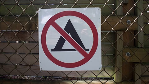 No camping signs line the fence at Gilman Park. As the COVID-19 pandemic has eased in King County, the City of Seattle is stepping up sweeps of homeless encampments. (Photo: Luke Brennan)