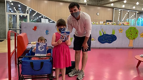 A family browses children's books at the Central Library. (Photo: Seattle Public Library)