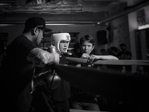 Reign City Athletics Boxing coaches Troy Pangilinan (right) and Ann Bailey (left) offer instruction to a young boxer. (Photo: Lorenzo Carlos Photography)
