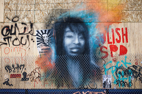 Portrait of Charleena Lyles, along with other art, decorates the outside of the abandoned Seattle Police East Precinct in June 2020. Photo is attributed to Derek Simeone (under a Creative Commons, CC BY 2.0 license).