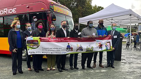 Local officials hold a banner announcing the RapidRide G Line expansion during a Sept. 30, 2021, press conference. (Photo: Ben Adlin)