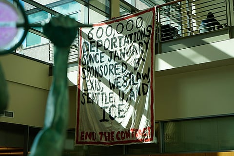 A banner hangs at the Seattle University Law School building to bring awareness to WestLaw's and LexisNexis' relationship with ICE and its impact. (Photo: Bunthay Cheam)