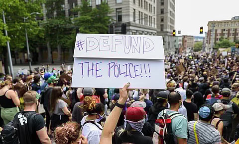 A demonstrator holds up a sign during a 2020 Seattle protest. (Photo: Alex Garland)