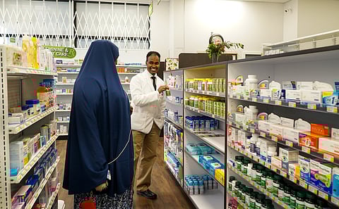 Pharmacist Dr. Ahmed Ali helps a customer at Othello Station Pharmacy. (Photo: Susan Fried)