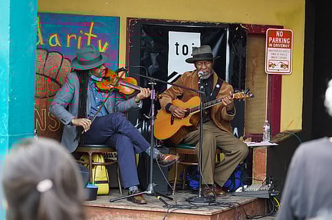 Ben Hunter (left) and Reggie Garrett (right) perform both classic blues and some of their own songs outside the Theatre Off Jackson during the Grand Launch event for the Seattle Green Book Tour on Sunday, March 27, 2022. The Theatre Off Jackson is next to the former site of the Golden West Hotel, which in 1939 was the only location in Seattle listed in the Green Book. (Photo: Susan Fried)