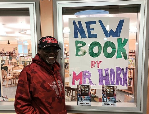 Alvin Horn in front of a display of his new book "Places to Be" at the library of the school where he works. Photo by librarian Mr. Englert.