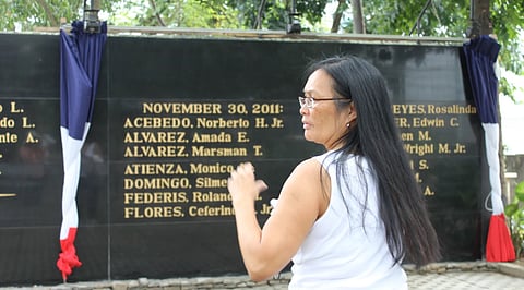 Cindy Domingo at the Bantayog ng mga Bayani (Wall of Martyrs), 2011, Quezon City, Philippines, in front of her brother Silme Domingo's name. He and Gene Viernes were the first Americans to be recognized on the Wall honoring the political victims of the Marcos Regime. (Photo: Sharon Maeda)