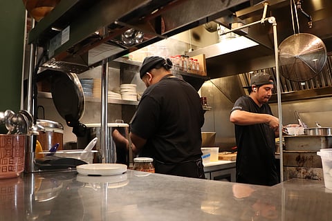 Kitchen staff Kyle Ronquillo (left) and Gerald Gutierrez (right) preparing for dinner service at Musang in North Beacon Hill on Tuesday, May 3, 2022. (Photo: Kyle Bender)