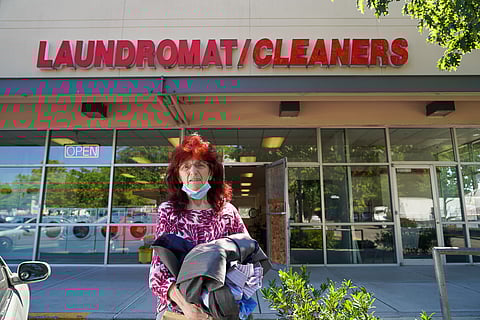 Bonniejean Crone standing in front of Polar Cleaners with some clothes dropped off by a customer a little while ago. (Photo: Jaidev Vella)