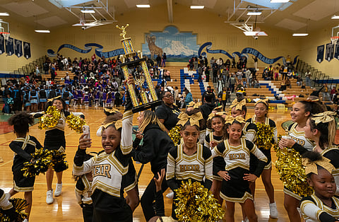 HEIR Academy cheerleaders hold up the trophy they shared with the Renton Rangers. Both teams tied for first place in the Northwest Premier Junior Football (NWPJF) Cheer Competition on Saturday, Nov. 5, at Mount Rainier High School in Des Moines. (Photo: Susan Fried)