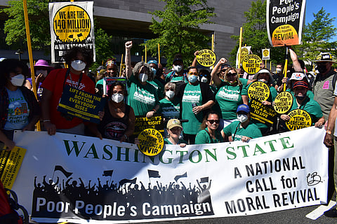 Washington Poor People's Campaign members proudly gather amidst a crowd to hold their chapter's banner while attending the Poor People's Campaign Mass Moral Assembly. Washington, D.C., on June 18, 2022. (Photo: Chardonnay Beaver)