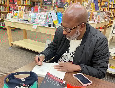 Max "Diego" Hunter, author of "Speech Is My Hammer: Black Male Literacy Narratives in the Age of Hip-Hop," signs a copy of his book.