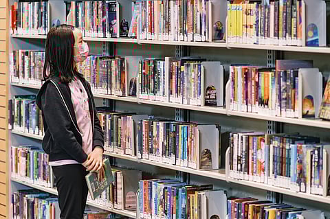 A young library patron browses the selection at the Beacon Hill Library. During a survey to determine priorities for Seattle's property levy tax fund, 98% of respondents said they considered libraries as essential as roads and schools. (Photo: Anthony Martinez)