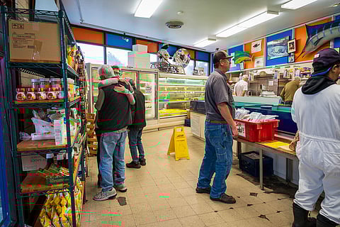 A customer hugs Harry Yoshimura as word spreads that South End's Mutual Fish is closing after decades in business on Rainier Avenue. (Photo: Ronnie Estoque)