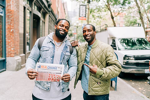 Robert Turbin (left) and Marcus Harrison Green (right) share the love from outside the Real Change offices on First Avenue South. (Photo: Nikki Barron, courtesy of Real Change)