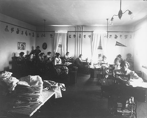 Native American girls in a sewing class at the Cushman Indian School in Tacoma in June 1918. One of the harmful tactics employed by Indian boarding schools was forced manual labor. During WWI, the Red Cross entered into a partnership with schools to produce needed good for war-torn countries. The girls photographed were likely sewing for the Red Cross. (Photo: Marvin D. Boland, Northwest Room at The Tacoma Public Library, BOLAND-B1187)