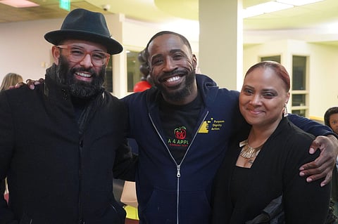 From left to right: Edwin Lindo, co-owner of Estelita's Library; Deaunte Damper, community advocate with VOCAL-WA; and DeVitta Briscoe, Gun Violence Prevention Liaison for the City of Seattle, pose for a photo after the community safety meeting on Jan. 19. (Photo: Julia Park)