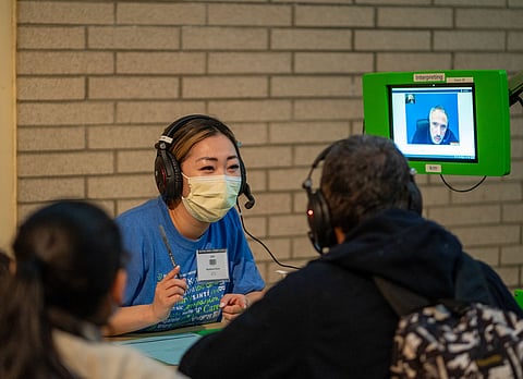 A volunteer with the help of a remote translator works with a patient at the annual Seattle/King County Clinic at Seattle Center on Thursday, Feb. 15. The annual clinic serves thousands of people, ranging from unemployed, students, immigrants, and others who do not have health insurance, are underinsured, or can't afford treatment. (Photo: Susan Fried)