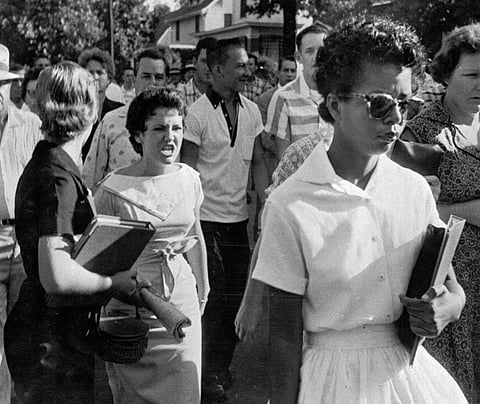 FILE - In this Sept. 4, 1957, file photo, students of Central High School in Little Rock, Ark., including Hazel Bryan, shout insults at Elizabeth Eckford as she calmly walks toward a line of National Guardsmen. The Guardsmen blocked the main entrance and would not let her enter. Monday, Sept. 25, 2017, marks 60 years since the Little Rock Nine first entered the school for classes. (Will Counts/Arkansas Democrat-Gazette via AP, File)