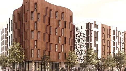 Architectural rendering of a modern urban development. The prominent building in the foreground features a wavy, terracotta-hued facade with irregularly placed windows, giving it a dynamic appearance. It's flanked by other multi-story buildings with varied designs, including one with a geometric-patterned facade. The street level shows spacious sidewalks with pedestrians, trees, and cyclists, suggesting a lively, pedestrian-friendly neighborhood.