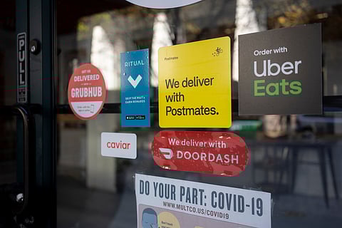 Various food delivery service options advertised at the entrance to a restaurant in Portland, Oregon, April 18, 2021. Photo via Tada Images/Shutterstock.com