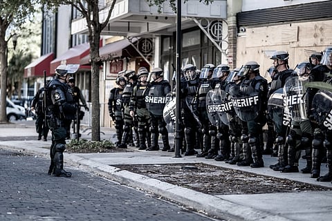 Police in riot gear facing down protestors in Tampa, Florida, in 2020. Photo via civilianllama/Shutterstock.com
