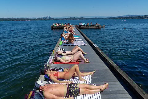 Dozens of people relax on the Arnold and Ema Park T-dock on Lake Washington on Monday, July 8. The temperature reached a record 93 degrees, resulting in hundreds of people descending on Lake Washington in search of relief from the heat. (Photo: Susan Fried)
