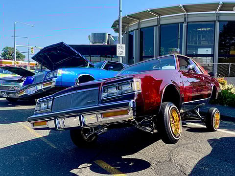 A red Buick displays its hydraulics set at the fourth annual Lowrider Block Party on July 20, 2024. (Photo: Jenn Ngeth)