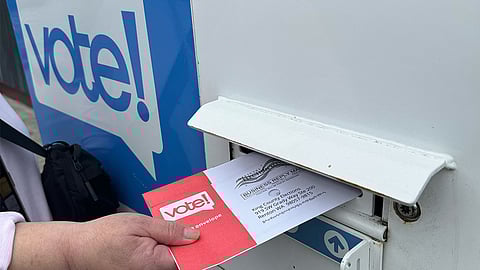 A King County voter drops off their ballot for the Aug. 6, 2024, primary at a drop box at the White Center Library. (Photo: Megan Christy)