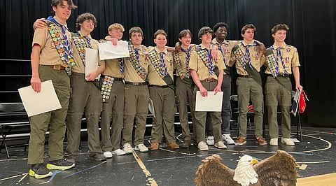 Students from Hanover High School and the area wearing their scouts uniforms on stage after earning the rank of Eagle Scout in a ceremony.